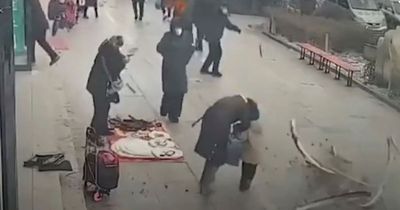 Hero mum shields child as glass panel plummets from shop and crashes towards them