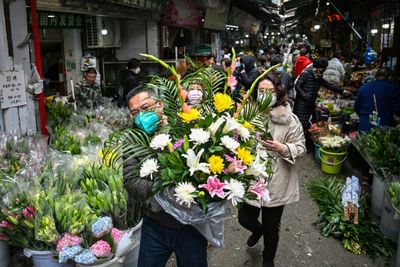 Bustling Wuhan markets celebrate New Year but grief remains