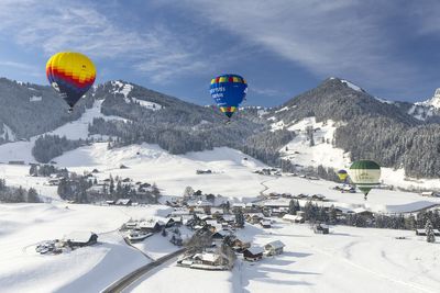 Hot air balloons soar over snowy Swiss town