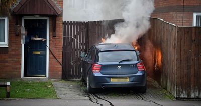 Moment man tries to extinguish BMW blaze on driveway before fire crews arrive