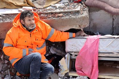 Heartbreaking photos show father clutching hand of dead daughter trapped in Turkey earthquake rubble