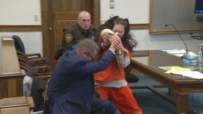 Woman accused in dismemberment slaying attacks her attorney