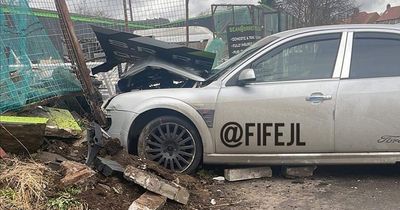 Woman rushed to hospital after car ploughs into fence in Scots town