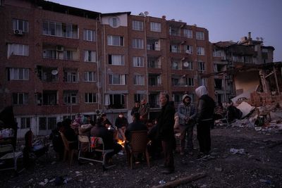 Quake survivors wait amid rubble, to search or say goodbye
