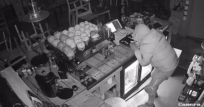 See the moment brazen thief rifles through café till before escaping through window