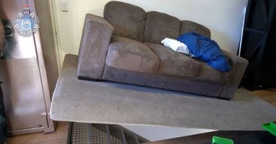 Terrifying hidden bunker found beneath sofa with arsenal of high-powered weapons