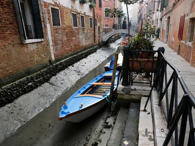 Historic venice canals reduced to muddy ditches by severe low tides