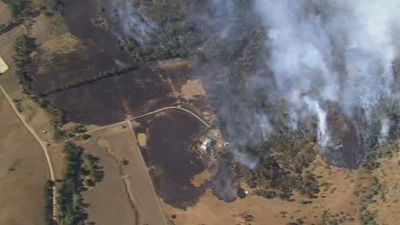 Dozens of crews work to contain out-of-control fire north of Melbourne as blaze threatens homes at Flowerdale, Yea