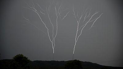 Upward lightning sprouting from broadcast towers near Robertson captured on camera by storm chaser