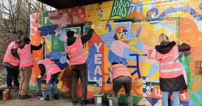 Volunteers help to restore graffiti-damaged murals