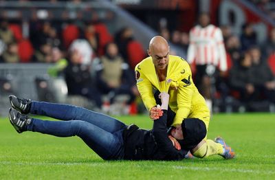 Sevilla goalkeeper Marko Dmitrovic attacked by pitch invader in PSV clash