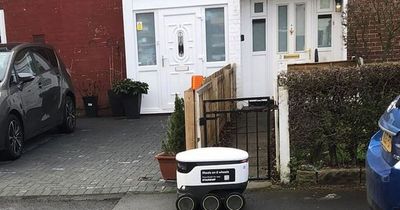 Locals left baffled after little white robot seen driving along street alone delivering packages