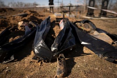A year into Ukraine war, bodies dug up in once occupied town