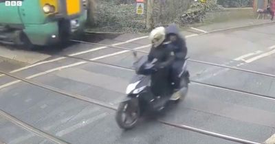 Horror moment moped driver is milliseconds away from being hit by train at level crossing