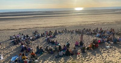 The women who meet on the beach around a fire under a full moon