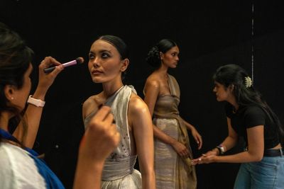 AP PHOTOS: Behind the runway glamour, a fashion army at work
