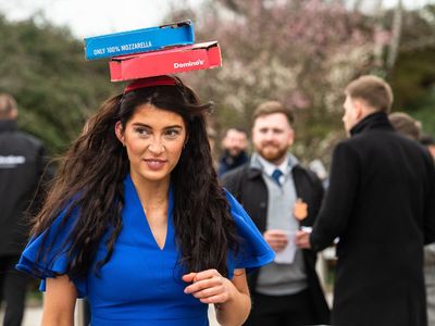 Woman hides a whole pizza in her fascinator at Cheltenham Festival Ladies Day