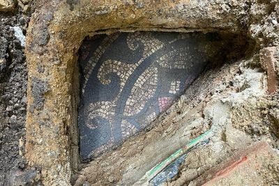 Work starts to unearth mosaic under pavement outside vape shop