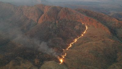 Fires west of Alice Springs spread, burning an estimated 100,000 hectares