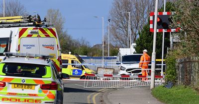 Trains cancelled and road closed as car crashes into level crossing barriers