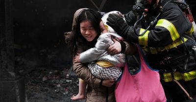 Woman with child in arms flees from mega New York blaze with crew tackling Chinatown fire