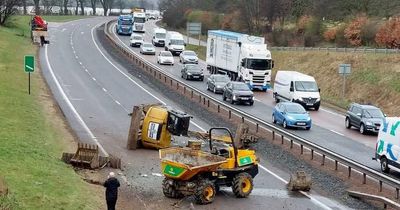 Digger falls off lorry after vehicle hit bridge with busy Scots road closed
