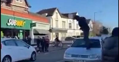 Woman cries hysterically in road as yob jumps on car and smashes windscreen