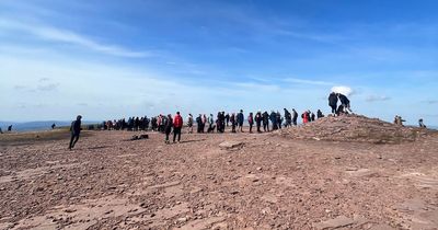 Long queues on top of Pen Y Fan as miles of cars are seen parked on grass verges