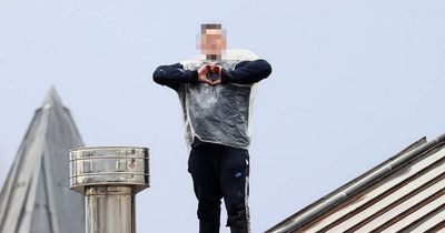 Strangeways prisoner 'wearing a binbag' makes love heart gesture to camera as he shouts from rooftop