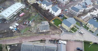 Drone image shows Midlothian cottage engulfed by new housing development