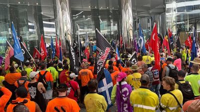 Police looking for man who allegedly broke $25,000 door of government building during CFMEU rally in Brisbane