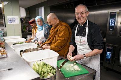 Welby urges people to volunteer on coronation weekend as he helps out at charity