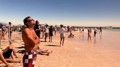 Thousands in awe as solar eclipse hits totality over the skies of northern Western Australia