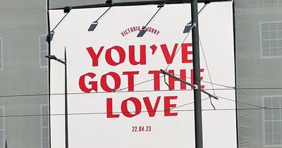 Loved up Edinburgh wedding couple cover venue scaffolding with touching message