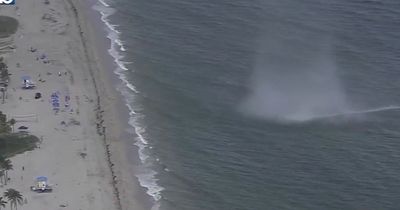 Terrifying moment waterspout makes landfall as tornado as beachgoers flee in fear