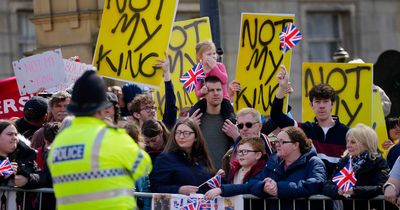 School children cheer and protesters chant 'not our king' as King Charles III visits library