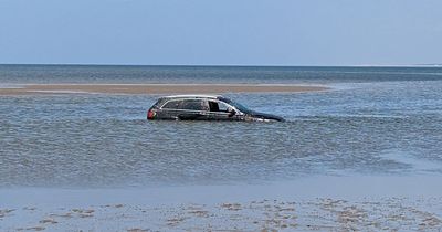 Driver's Audi submerged in sea after getting stuck in sand on beach