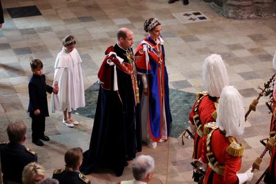 Prince Louis and Princess Charlotte hold hands during abbey arrival