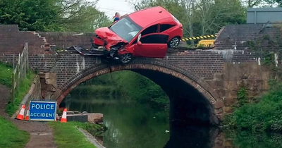 Car left hanging over bridge as passenger avoids injury by jumping into canal