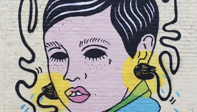 What are the panthers in this Albany Park mural telling this woman?