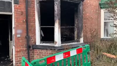 Man and woman dead after fire rips through home as floral tributes left at scene