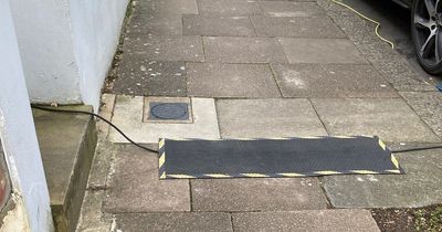 Picture of electric car wire across pavement sparks fierce charging point debate