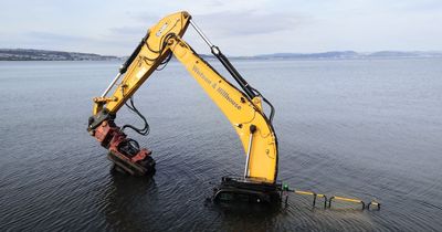 Digger ends up submerged by the tide on beach at Mumbles
