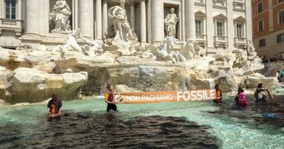 Climate activists dye famous Rome fountain black after floods kill at least 15