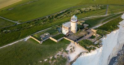Huge part of iconic UK cliff collapses into the sea with lighthouse teetering on edge
