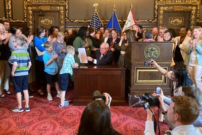 Minnesota governor signs paid family and medical leave act to give workers up to 20 weeks off