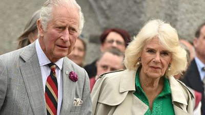 Queen Camilla proves trench coats go with everything as she pairs hers with stunning emerald green tunic dress