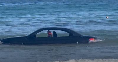 BMW convertible drifts out to sea after owner parked motor on beach