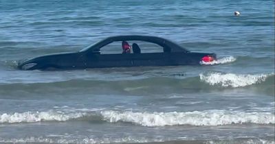 BMW drifts out to sea after owner parks it on beach