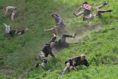 Rolling thunder: Contestants chase cheese wheel down a hill in chaotic UK race